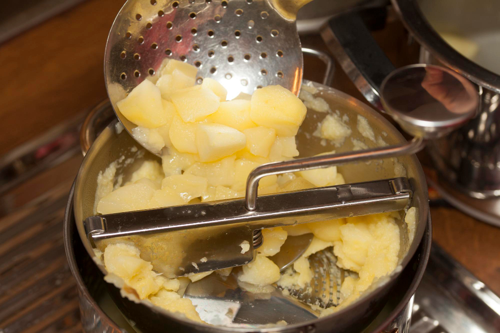 Potatoes being mashed into smooth uniform texture at Shiv Shree Food